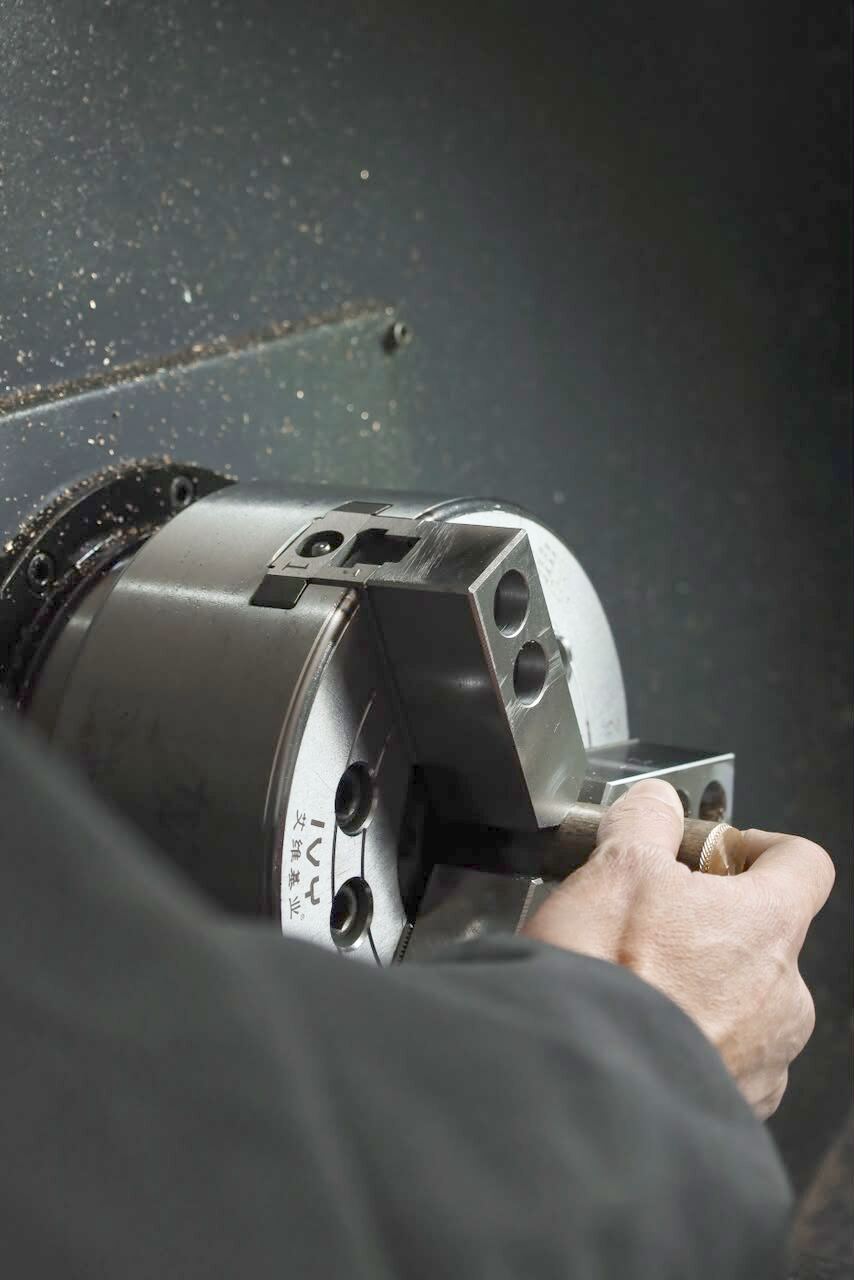 Metal component being turned on the lathe in the Streamlight machine shop