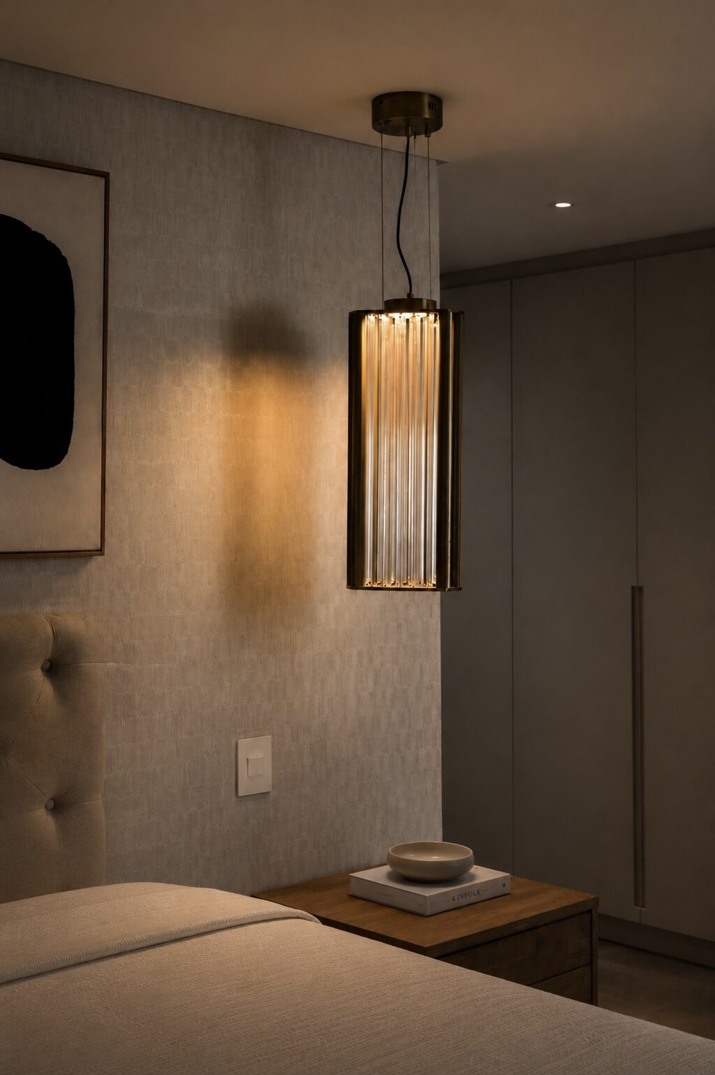 Brass and glass rod pendant light beside a bed, decorative bedroom lighting by Streamlight