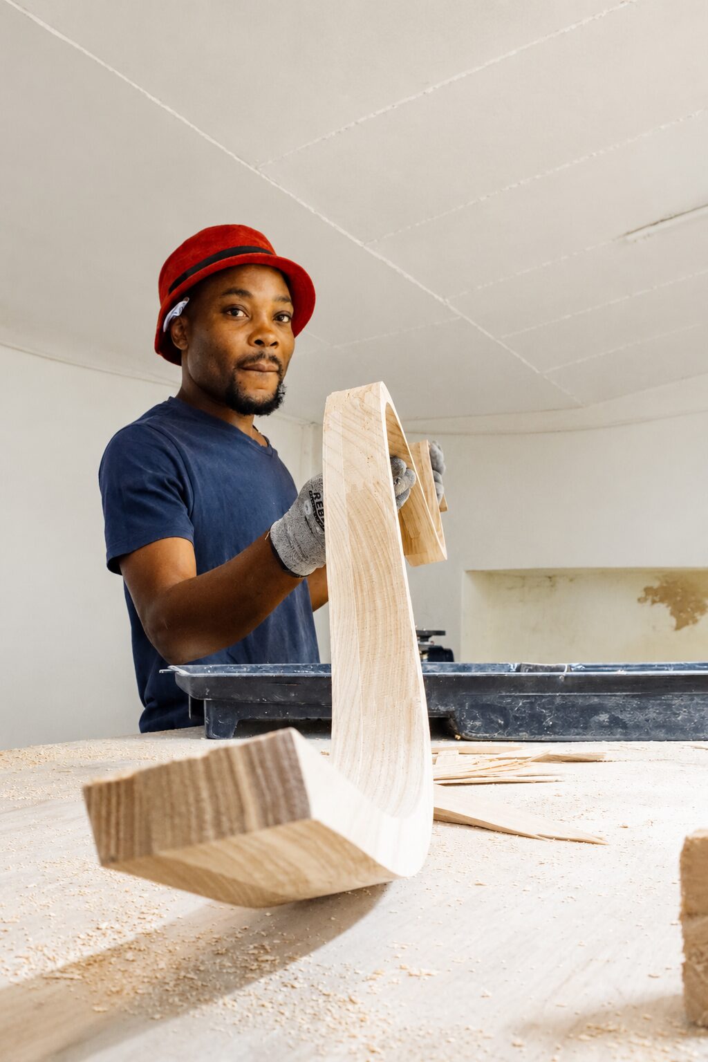 Streamlight craftsman hand-shaping a curved timber light fixture component